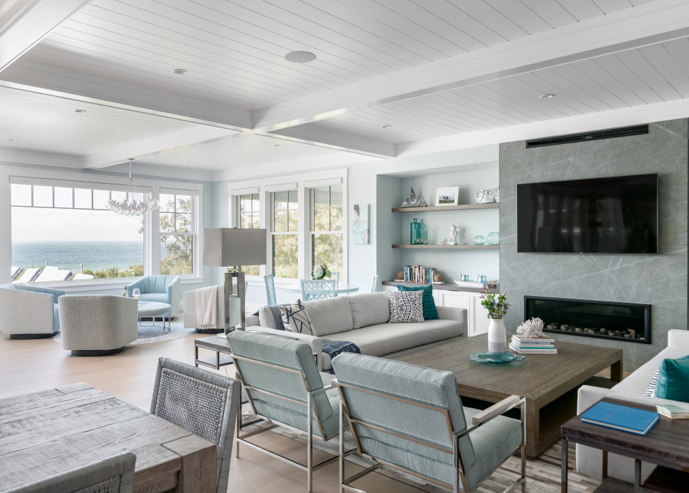 Стильный дизайн: открытая гостиная комната в морском стиле с серыми стенами, светлым паркетным полом, горизонтальным камином, телевизором на стене, бежевым полом и потолком из вагонки - последний тренд