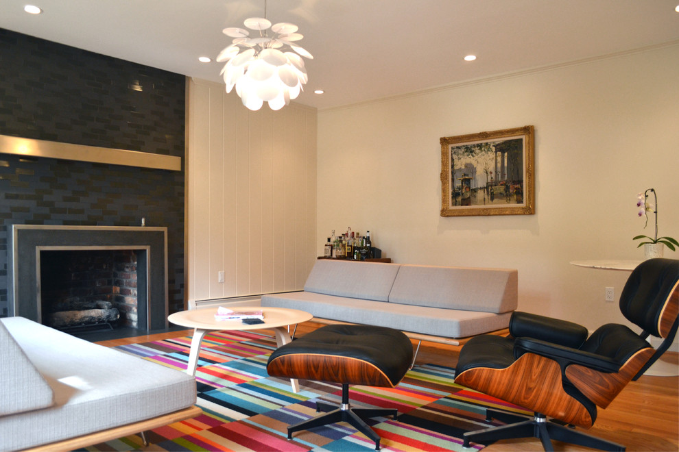 Immagine di un piccolo soggiorno minimalista chiuso con pareti bianche, parquet chiaro e cornice del camino piastrellata