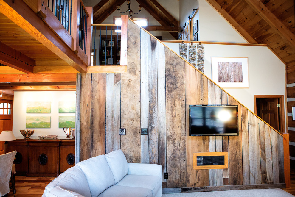 Ejemplo de salón abierto rústico de tamaño medio con paredes beige, suelo de madera en tonos medios, todas las chimeneas, marco de chimenea de madera y televisor colgado en la pared