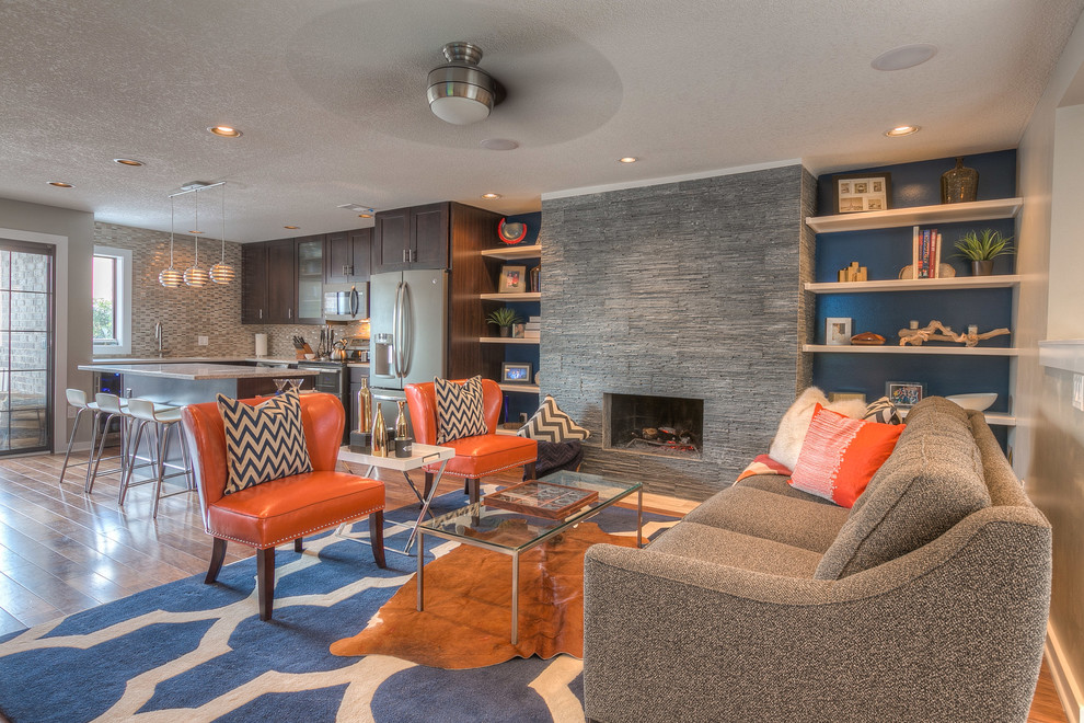 Foto de salón abierto moderno de tamaño medio con paredes azules, suelo de madera en tonos medios, todas las chimeneas y marco de chimenea de piedra