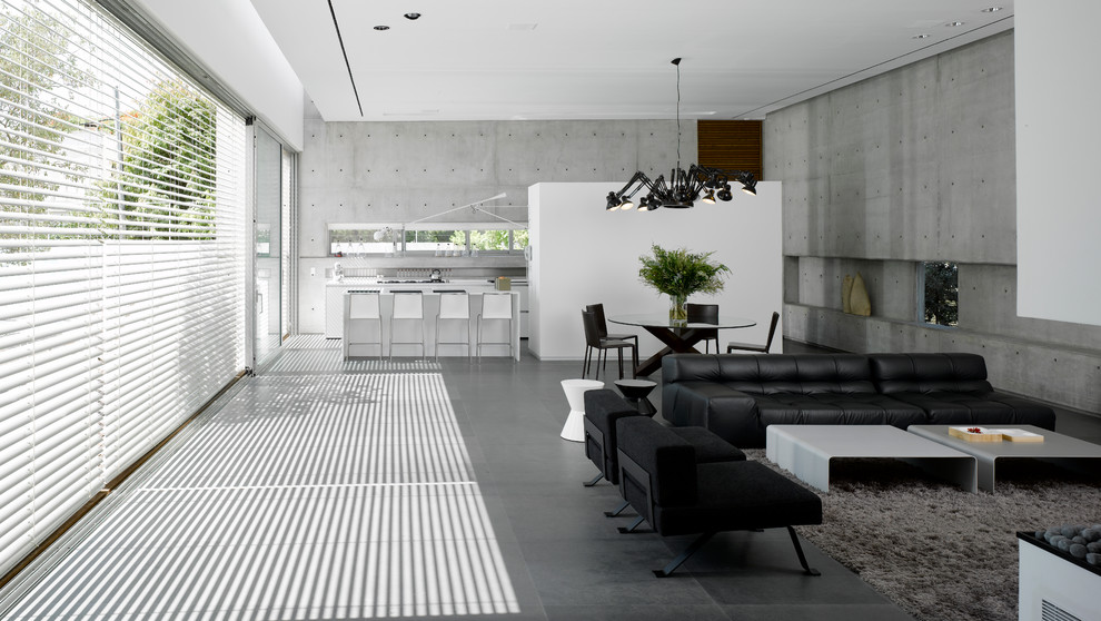 Foto de salón abierto y cemento urbano grande sin chimenea y televisor con suelo de cemento, paredes grises y suelo gris
