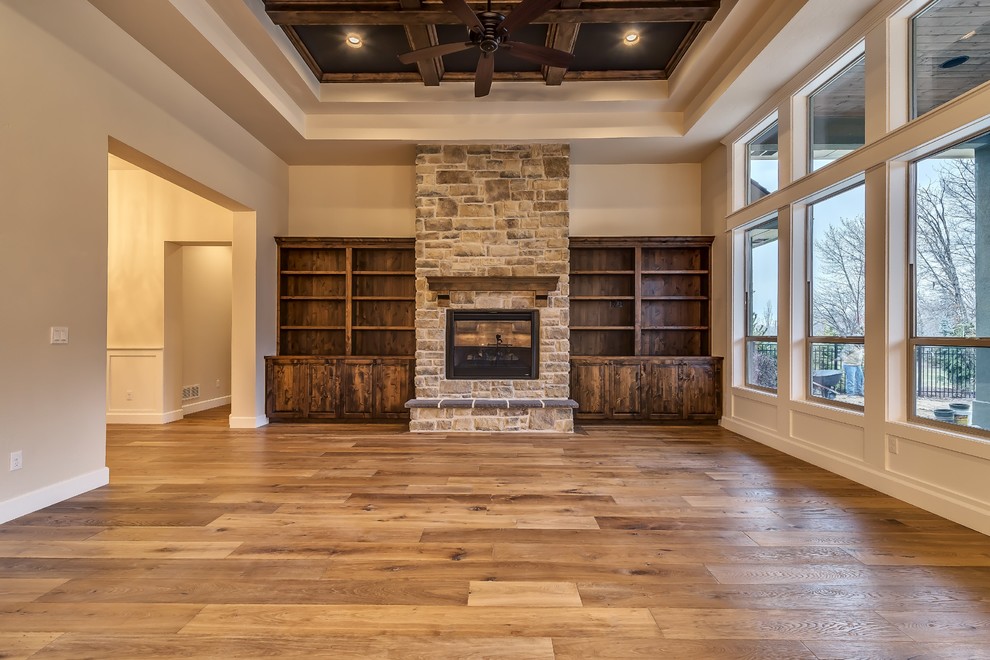 Großes, Fernseherloses, Offenes Klassisches Wohnzimmer mit beiger Wandfarbe, braunem Holzboden, Kamin und Kaminumrandung aus Stein in Boise