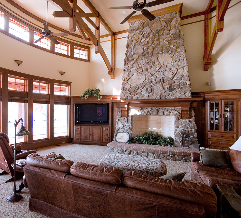 Photo of a large rustic mezzanine living room in Chicago with a stone fireplace surround and a built-in media unit.