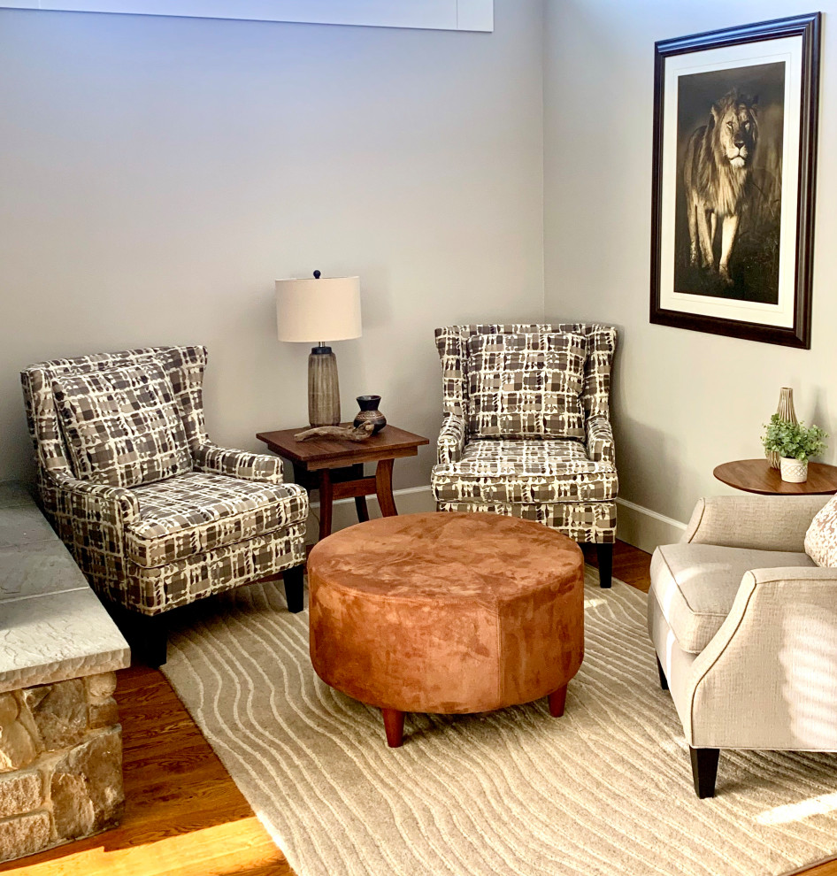 Стильный дизайн: большая открытая гостиная комната в стиле ретро с с книжными шкафами и полками, серыми стенами, паркетным полом среднего тона, двусторонним камином, фасадом камина из камня, телевизором на стене и коричневым полом - последний тренд
