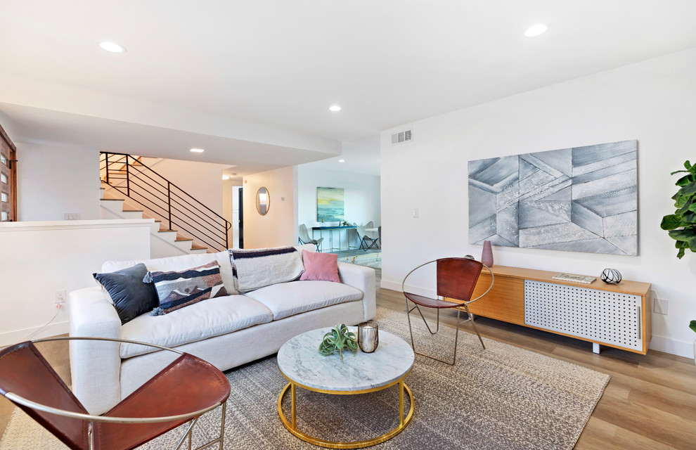 Klassisches Wohnzimmer mit weißer Wandfarbe, braunem Holzboden und braunem Boden in Los Angeles