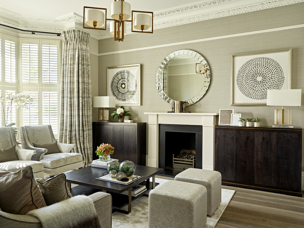 Design ideas for a small classic formal living room in London with medium hardwood flooring, a standard fireplace, a stone fireplace surround, a concealed tv, grey walls and brown floors.