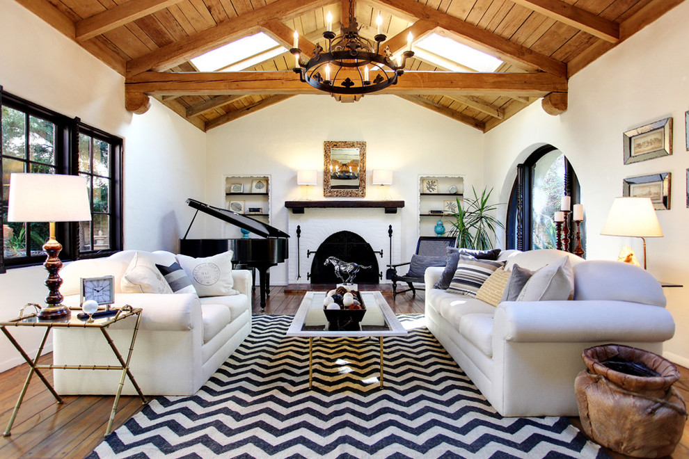 Uriges Wohnzimmer mit weißer Wandfarbe, braunem Holzboden, Kamin und Kaminumrandung aus Backstein in Sonstige