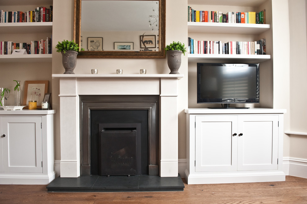 Mid-sized minimalist enclosed medium tone wood floor living room photo in London with beige walls, a standard fireplace, a tv stand and a stone fireplace