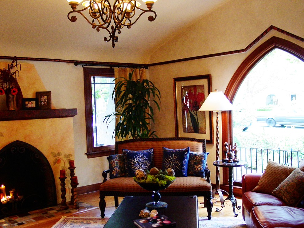 Exemple d'un salon victorien de taille moyenne et fermé avec une salle de réception, un mur beige, un sol en bois brun, une cheminée standard, un manteau de cheminée en plâtre, aucun téléviseur et un sol beige.