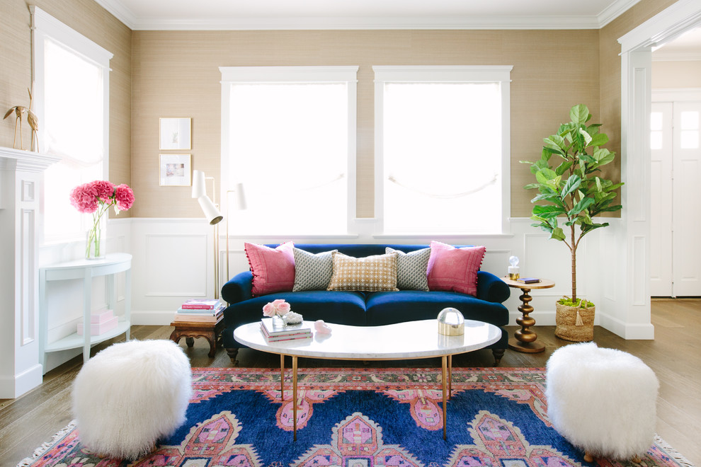 Mid-sized transitional formal medium tone wood floor living room photo in Los Angeles with beige walls, a standard fireplace and no tv