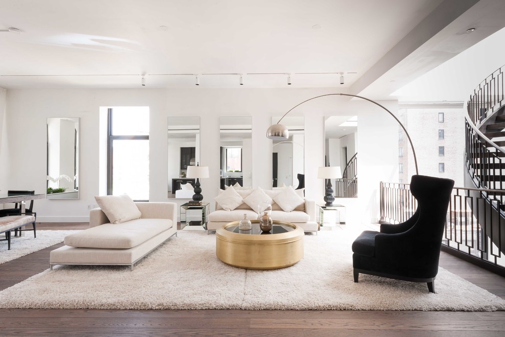 This is an example of a contemporary open plan living room in New York with white walls and dark hardwood flooring.