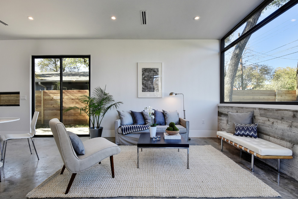 Repräsentatives, Offenes Modernes Wohnzimmer mit grauer Wandfarbe und Betonboden in Austin
