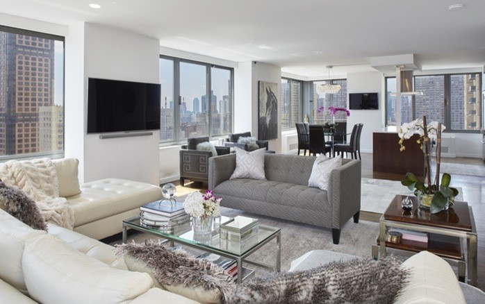 This is an example of a large contemporary formal open plan living room in New York with white walls, a wall mounted tv, no fireplace and carpet.