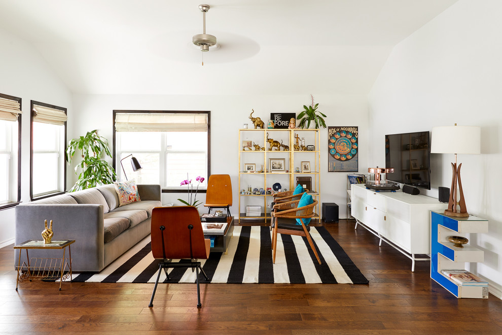 Источник вдохновения для домашнего уюта: большая открытая гостиная комната в стиле фьюжн с белыми стенами, телевизором на стене, коричневым полом, темным паркетным полом и ковром на полу