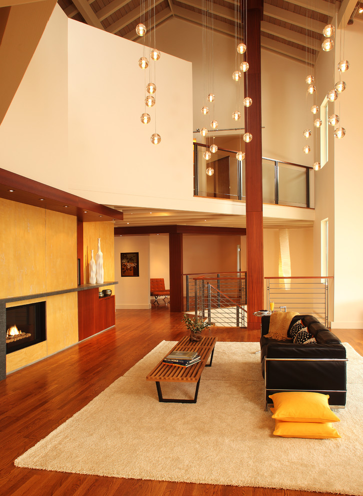 Inspiration for a large modern open concept medium tone wood floor living room library remodel in San Francisco with a standard fireplace, a plaster fireplace, yellow walls and no tv