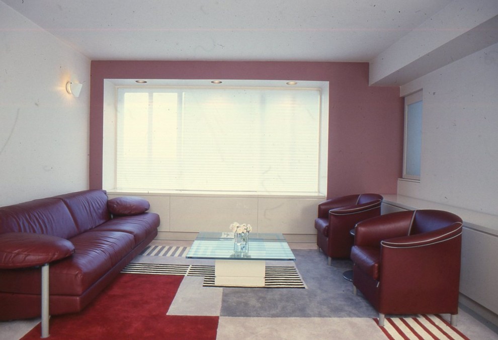 Ejemplo de salón tipo loft minimalista grande sin televisor con paredes rojas y suelo de madera clara