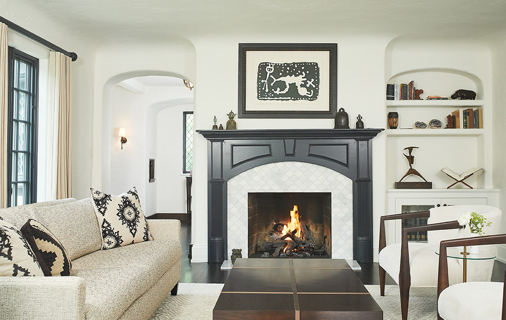 グランドラピッズにある広いトランジショナルスタイルのおしゃれなリビング (ベージュの壁、濃色無垢フローリング、標準型暖炉、タイルの暖炉まわり、テレビなし、茶色い床) の写真