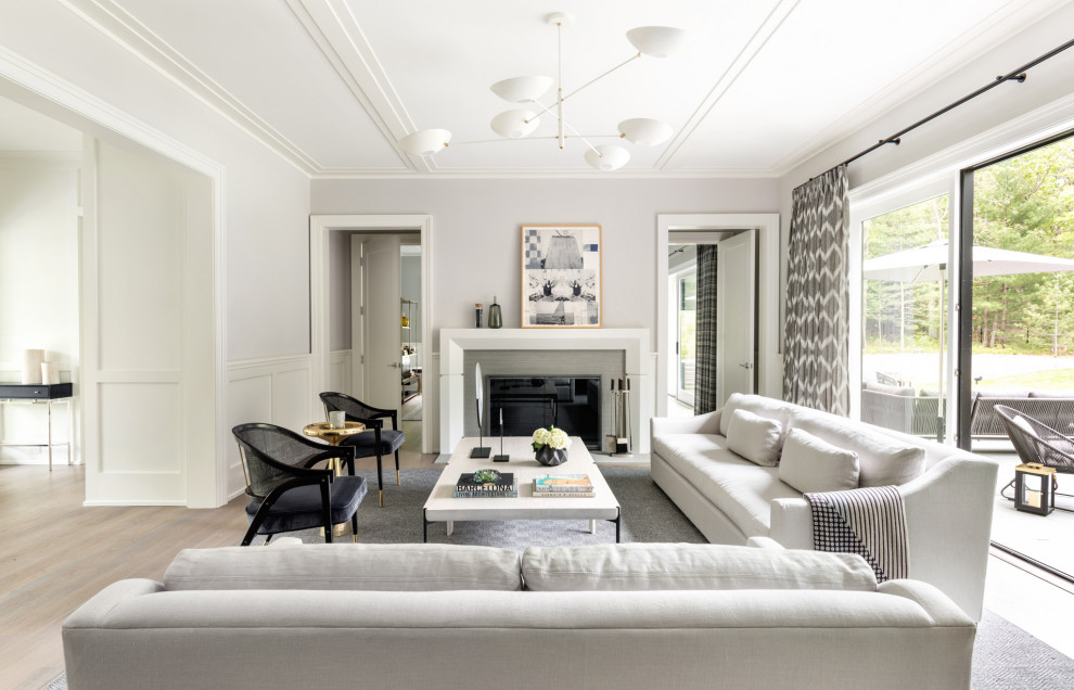 Пример оригинального дизайна: большая парадная, открытая гостиная комната в стиле неоклассика (современная классика) с серыми стенами, стандартным камином, бежевым полом и панелями на стенах без телевизора