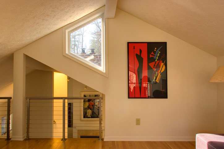 Fernseherloses Modernes Wohnzimmer ohne Kamin, im Loft-Stil mit beiger Wandfarbe und braunem Holzboden in Indianapolis