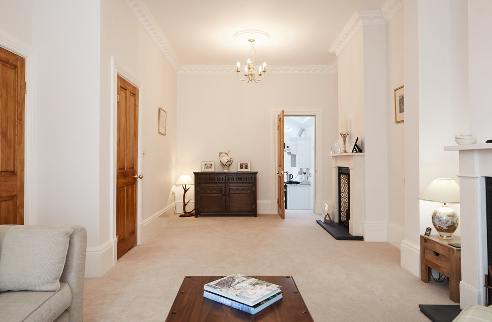 Medium sized traditional formal enclosed living room in London with white walls, carpet, a standard fireplace, a metal fireplace surround and a wall mounted tv.