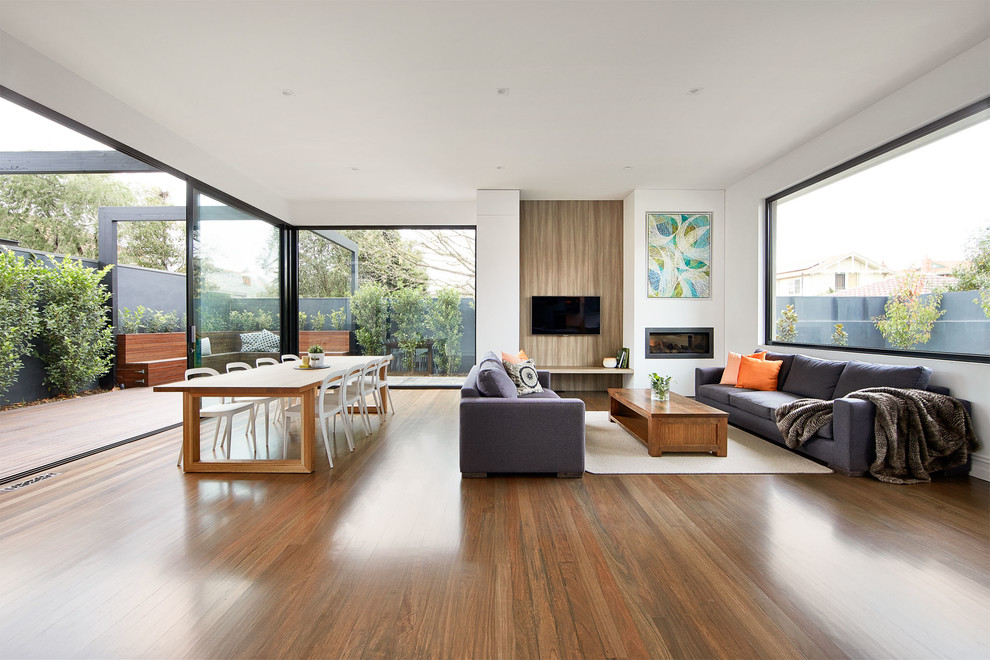 Inspiration for a contemporary formal open plan living room in Melbourne with white walls, medium hardwood flooring, a ribbon fireplace and a wall mounted tv.