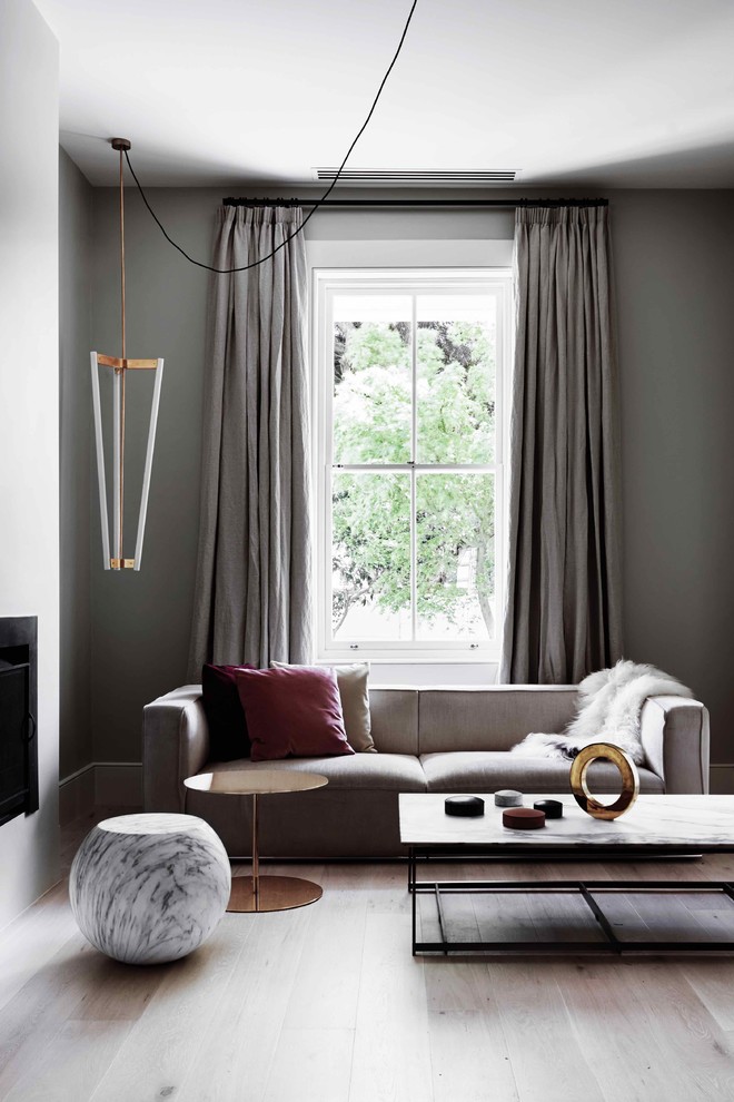 Example of a mid-sized trendy open concept light wood floor living room design in Melbourne with gray walls and a standard fireplace