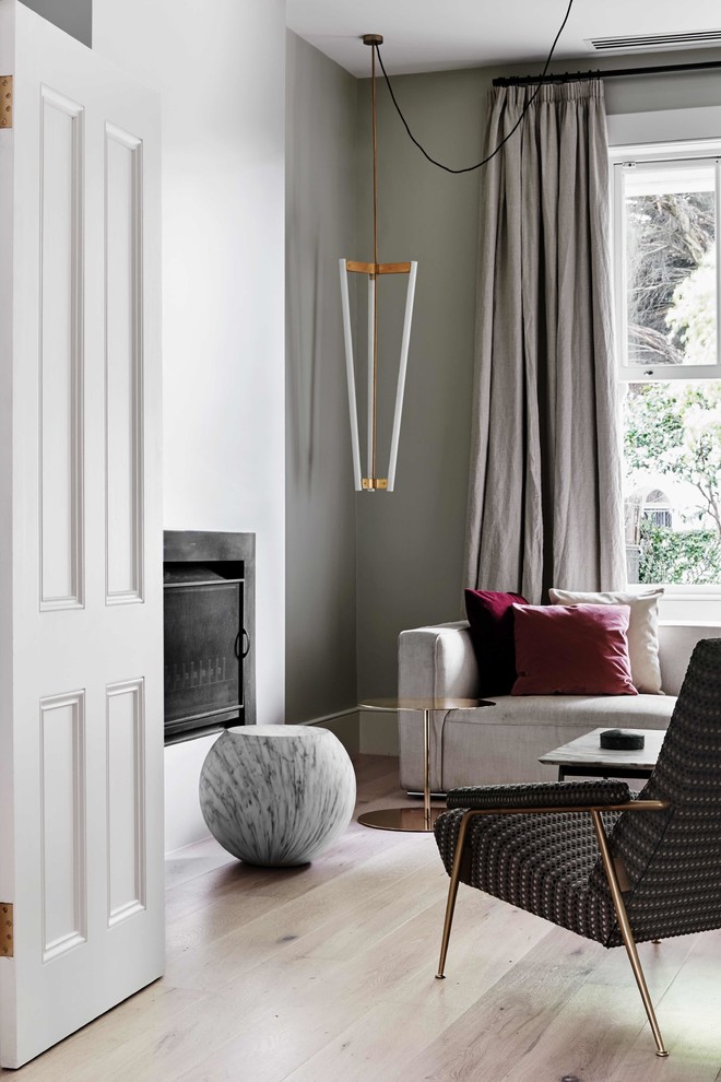 Aménagement d'un salon contemporain avec un mur gris, parquet clair et une cheminée standard.