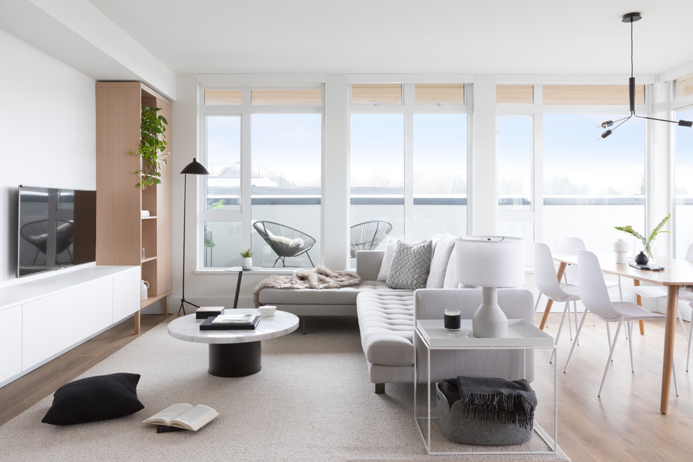 Inspiration pour un salon design ouvert avec un mur blanc, un sol en bois brun, un téléviseur fixé au mur et un sol marron.