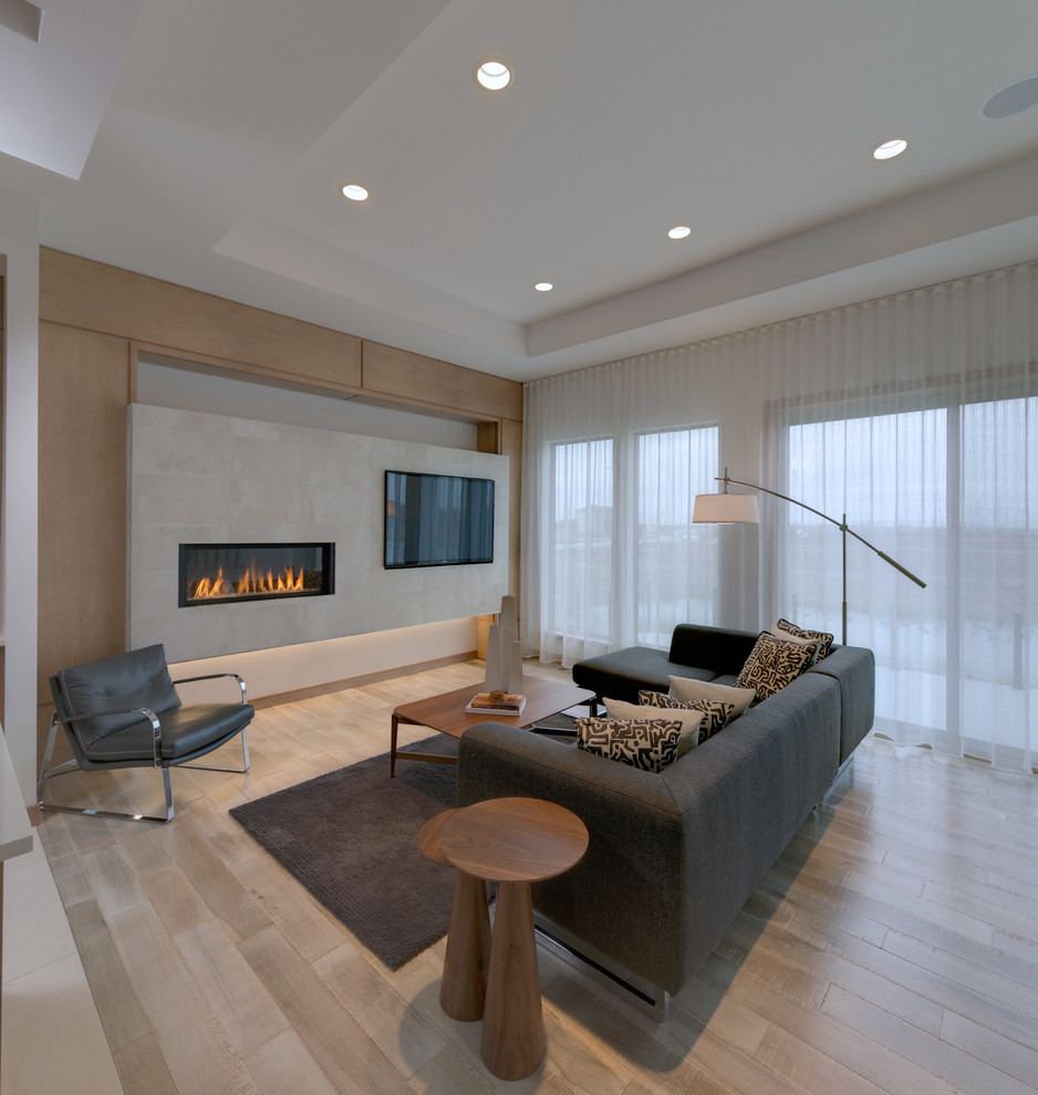 This is an example of a medium sized contemporary open plan living room in Other with beige walls, light hardwood flooring, a ribbon fireplace, a wall mounted tv, a concrete fireplace surround, beige floors and feature lighting.