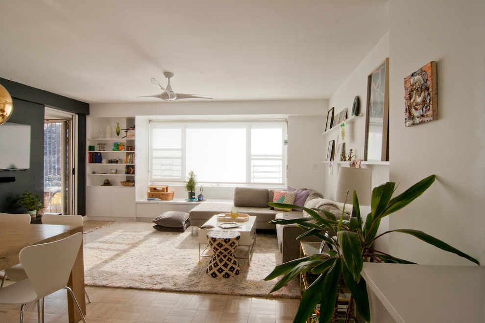 Esempio di un piccolo soggiorno moderno aperto con pareti nere, parquet chiaro, TV a parete e pavimento beige