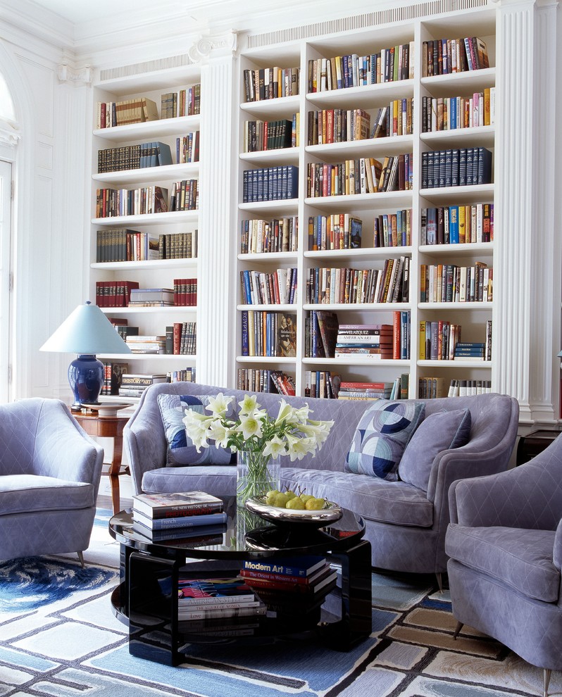 Пример оригинального дизайна: гостиная комната в стиле неоклассика (современная классика) с с книжными шкафами и полками и синим диваном
