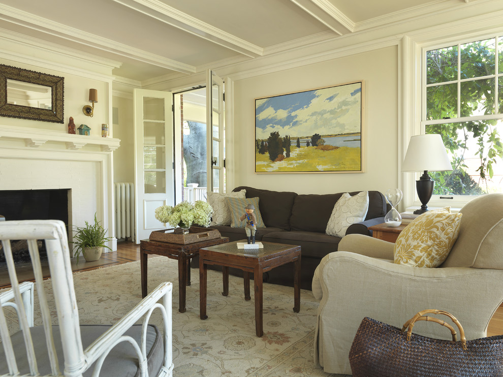 Immagine di un soggiorno tradizionale con pareti beige e camino classico