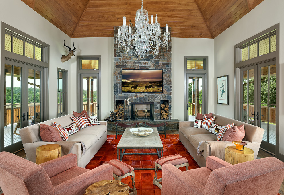 Living room - mid-sized southwestern open concept medium tone wood floor and brown floor living room idea in Dallas with beige walls, a standard fireplace, a stone fireplace and a wall-mounted tv