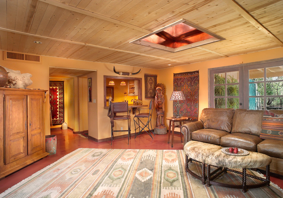 Идея дизайна: открытая гостиная комната в стиле рустика с оранжевыми стенами и бетонным полом