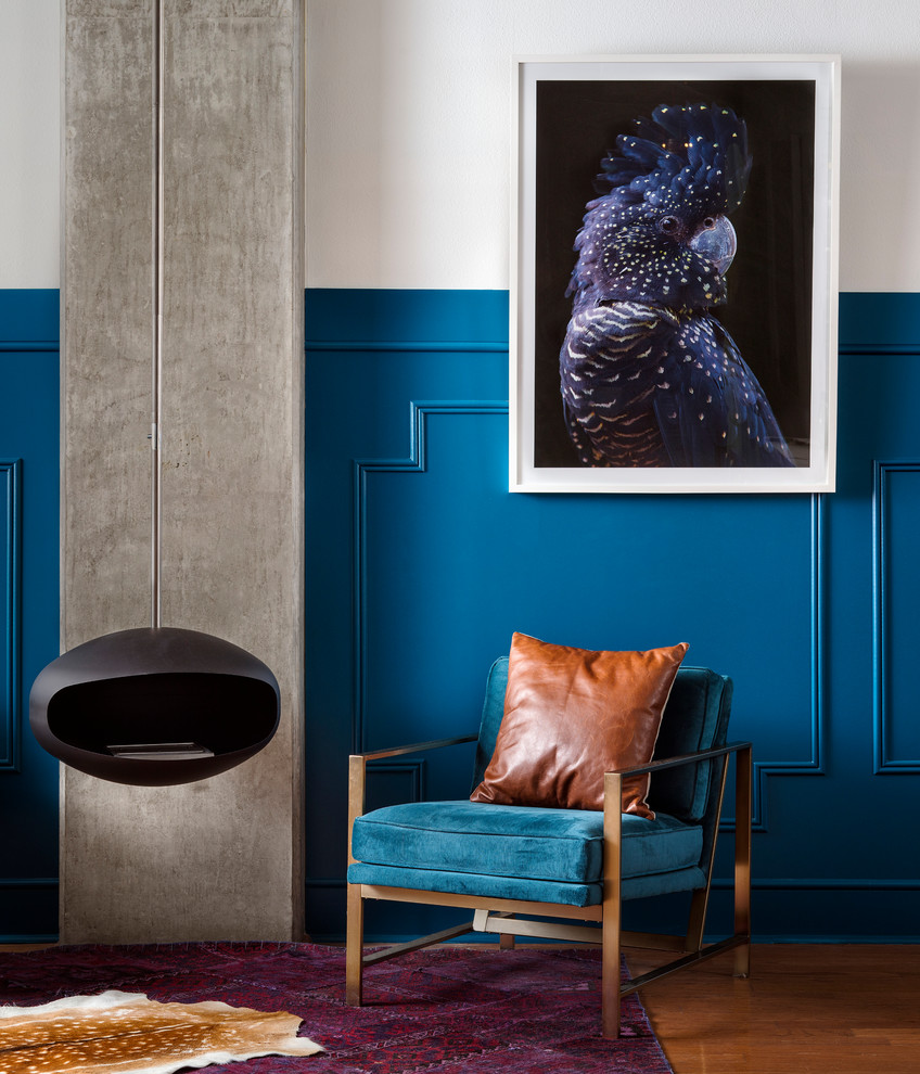 Idee per un soggiorno eclettico di medie dimensioni con pareti blu, pavimento in legno massello medio, pavimento marrone e camino sospeso