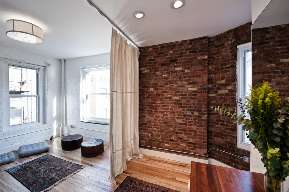 Example of a trendy medium tone wood floor living room design in New York