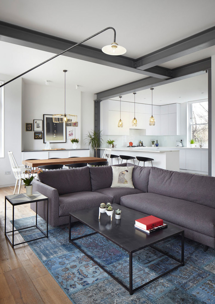 Offenes Modernes Wohnzimmer mit weißer Wandfarbe, braunem Holzboden und braunem Boden in New York