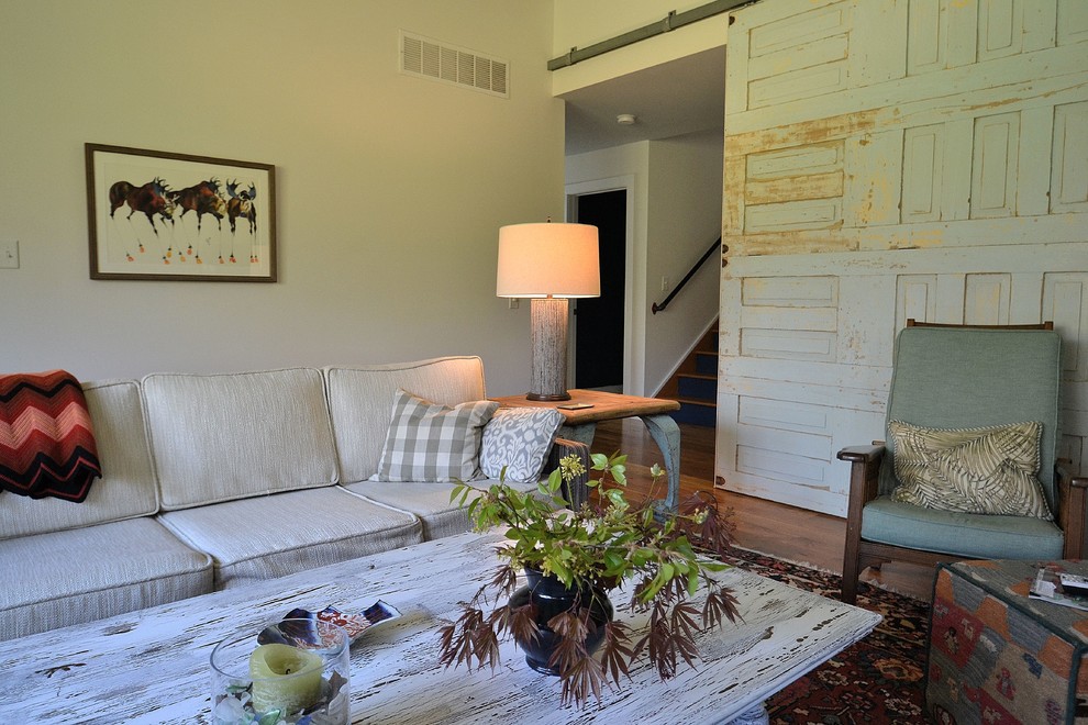 Cette photo montre un grand salon romantique fermé avec un mur blanc, un sol en bois brun, une cheminée standard, un manteau de cheminée en brique, un téléviseur fixé au mur et un sol marron.