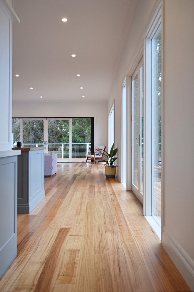 Großes, Offenes Nordisches Wohnzimmer mit weißer Wandfarbe und hellem Holzboden in Melbourne
