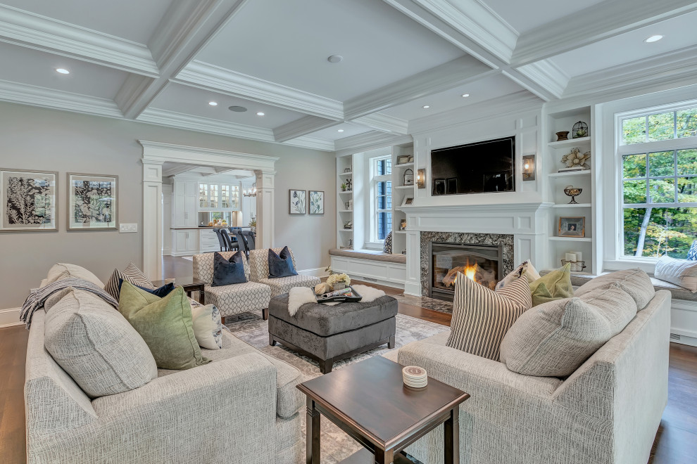 Large classic formal enclosed living room in New York with dark hardwood flooring, a standard fireplace, a stone fireplace surround, brown floors, grey walls, a wall mounted tv and a coffered ceiling.