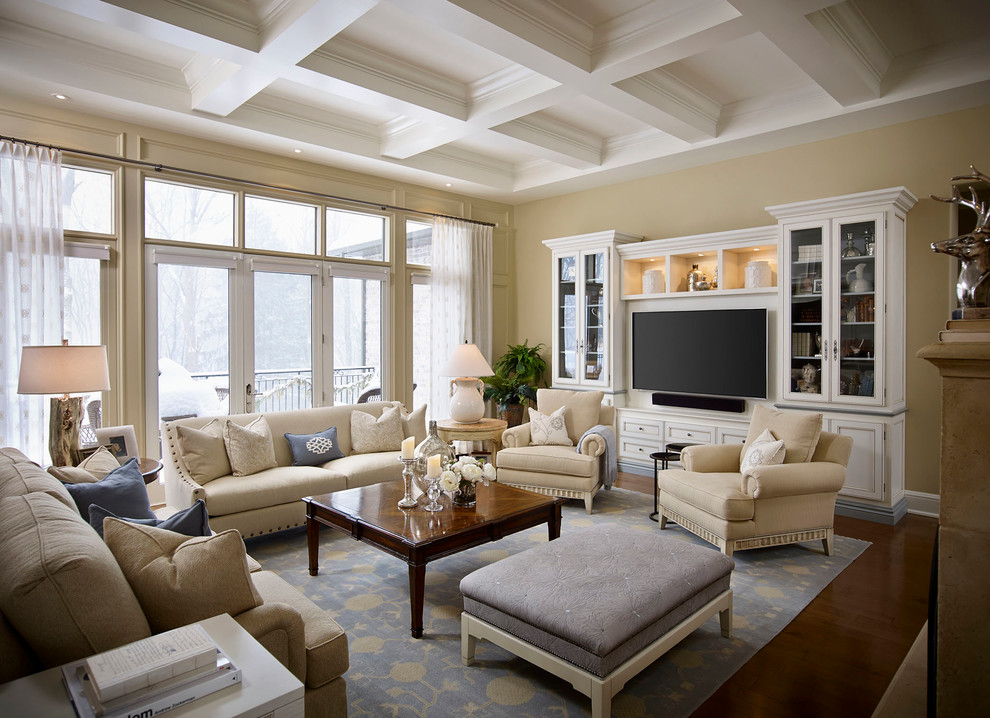 Imagen de salón abierto clásico grande con paredes beige, suelo de madera oscura y pared multimedia