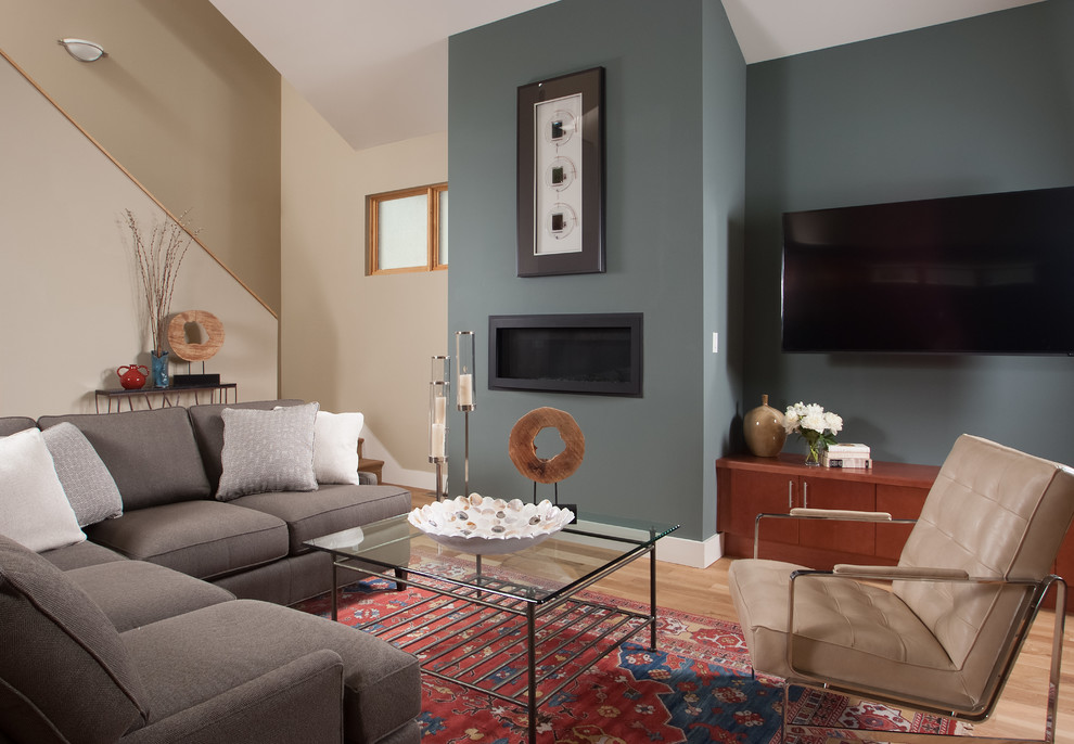Свежая идея для дизайна: большая открытая гостиная комната в современном стиле с серыми стенами, светлым паркетным полом, стандартным камином, фасадом камина из металла, телевизором на стене и коричневым полом - отличное фото интерьера
