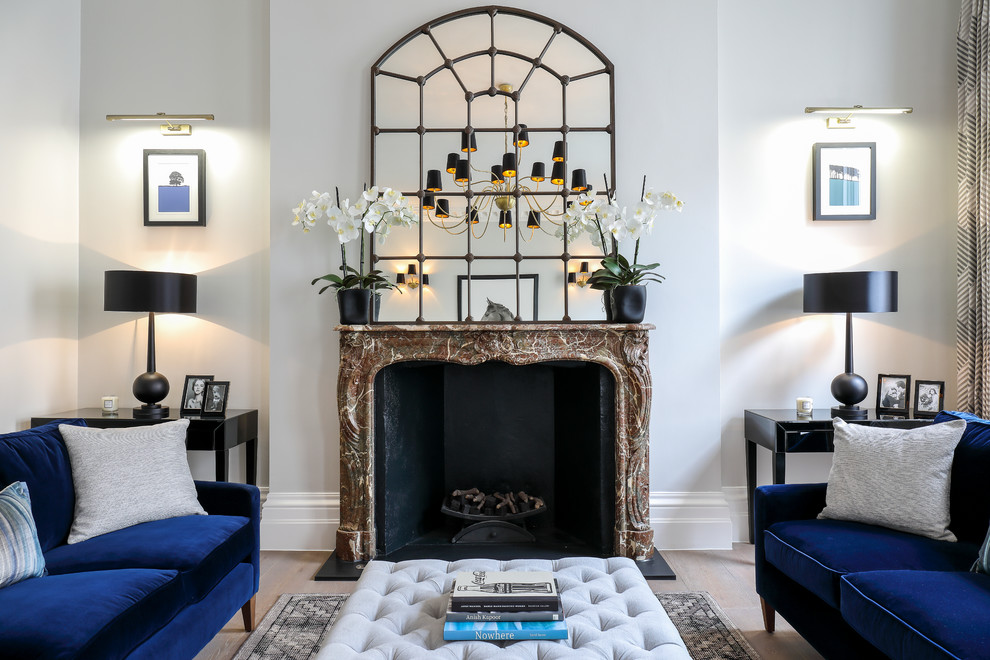 Repräsentatives, Fernseherloses Eklektisches Wohnzimmer mit grauer Wandfarbe, hellem Holzboden, Kamin und Kaminumrandung aus Stein in London
