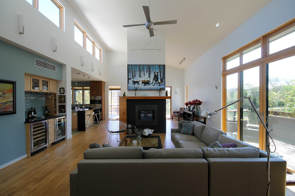 Photo of a large modern open plan living room in Atlanta with white walls, light hardwood flooring, a two-sided fireplace, a tiled fireplace surround and no tv.