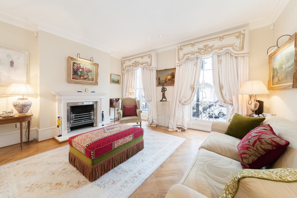 Esempio di un soggiorno tradizionale di medie dimensioni con sala formale, pareti beige, parquet chiaro, camino classico e pavimento beige
