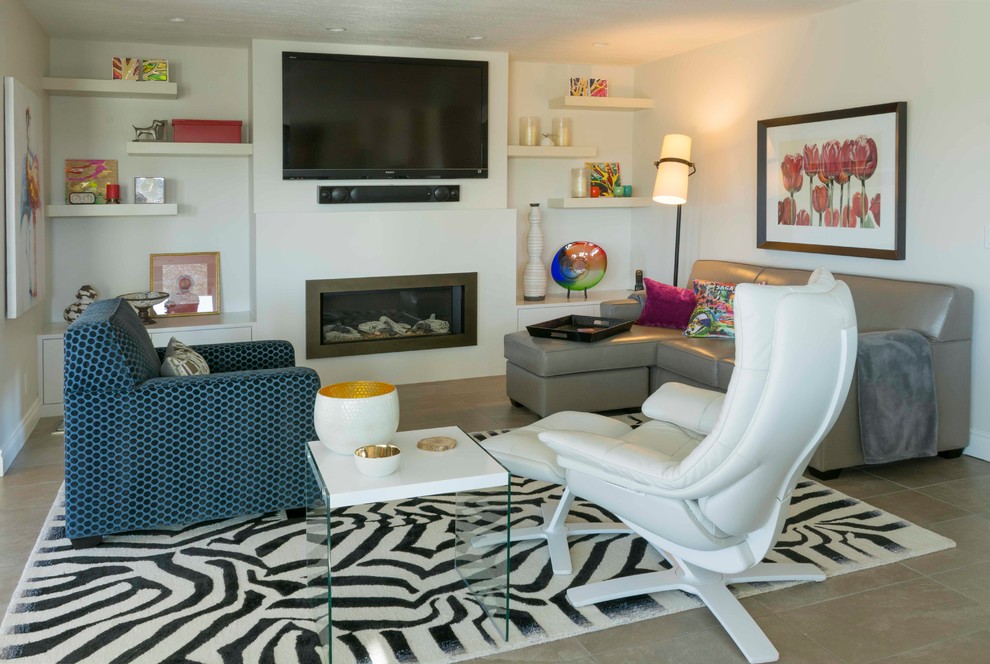Mittelgroßes, Offenes Eklektisches Wohnzimmer mit weißer Wandfarbe, Keramikboden, Hängekamin, Kaminumrandung aus Stein, TV-Wand und grauem Boden in Calgary