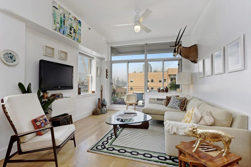 Kleines, Offenes Modernes Wohnzimmer ohne Kamin mit weißer Wandfarbe, hellem Holzboden, TV-Wand und braunem Boden in New York