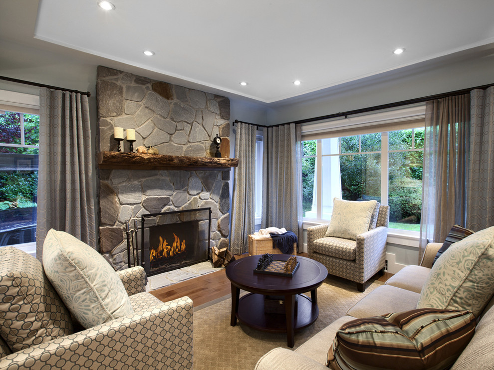 Стильный дизайн: гостиная комната в стиле неоклассика (современная классика) с стандартным камином, фасадом камина из камня и красивыми шторами - последний тренд