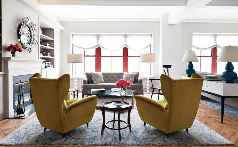 Photo of an eclectic living room in New York with white walls, medium hardwood flooring and a standard fireplace.