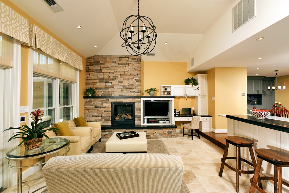 На фото: гостиная комната в стиле фьюжн с фасадом камина из камня и желтыми стенами с